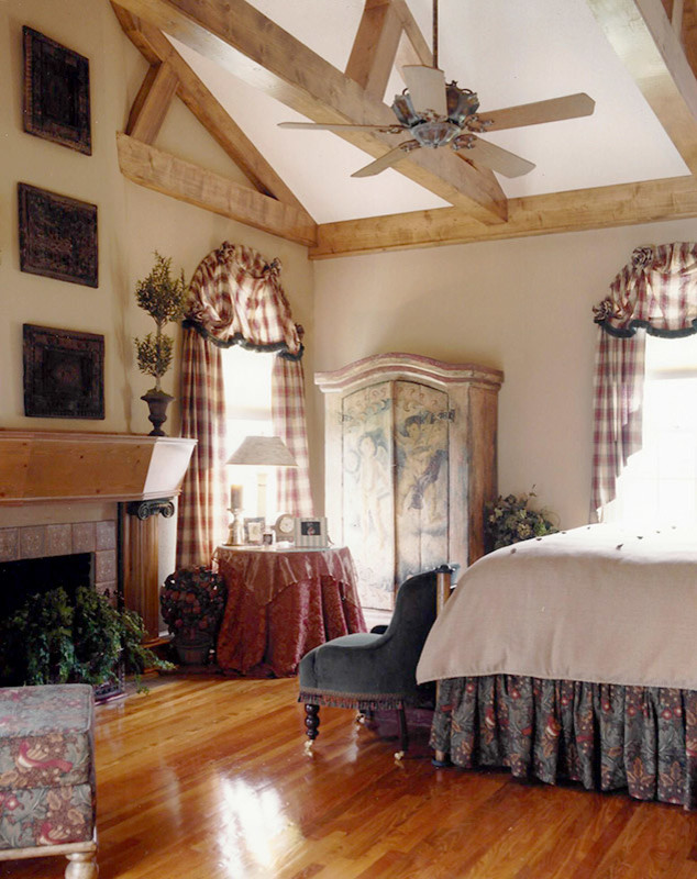 Diseño de dormitorio principal clásico grande con paredes beige, suelo de madera en tonos medios, todas las chimeneas, marco de chimenea de baldosas y/o azulejos y suelo beige