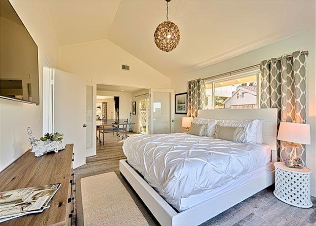 This is an example of a medium sized coastal guest bedroom in San Diego with white walls, ceramic flooring and no fireplace.