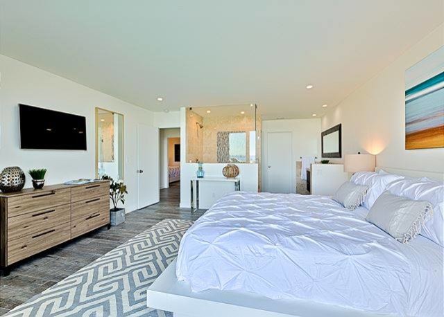 Ejemplo de dormitorio principal costero de tamaño medio sin chimenea con paredes blancas y suelo de baldosas de cerámica