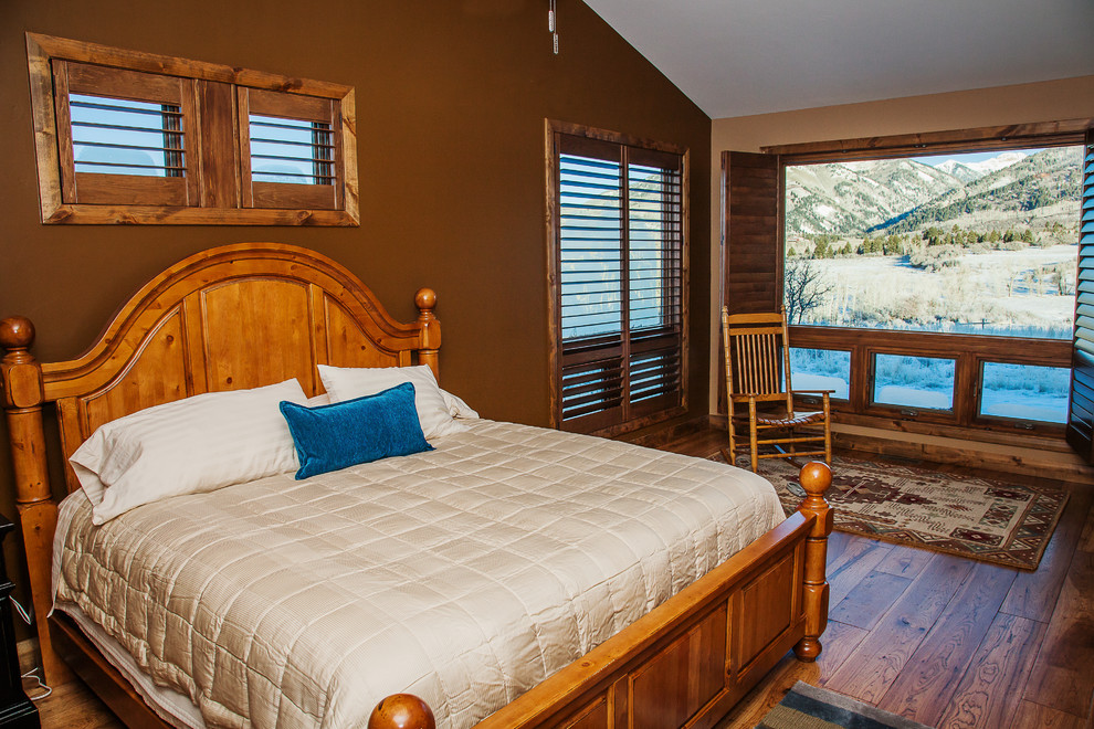 Ejemplo de dormitorio principal rústico de tamaño medio con paredes marrones y suelo de madera en tonos medios