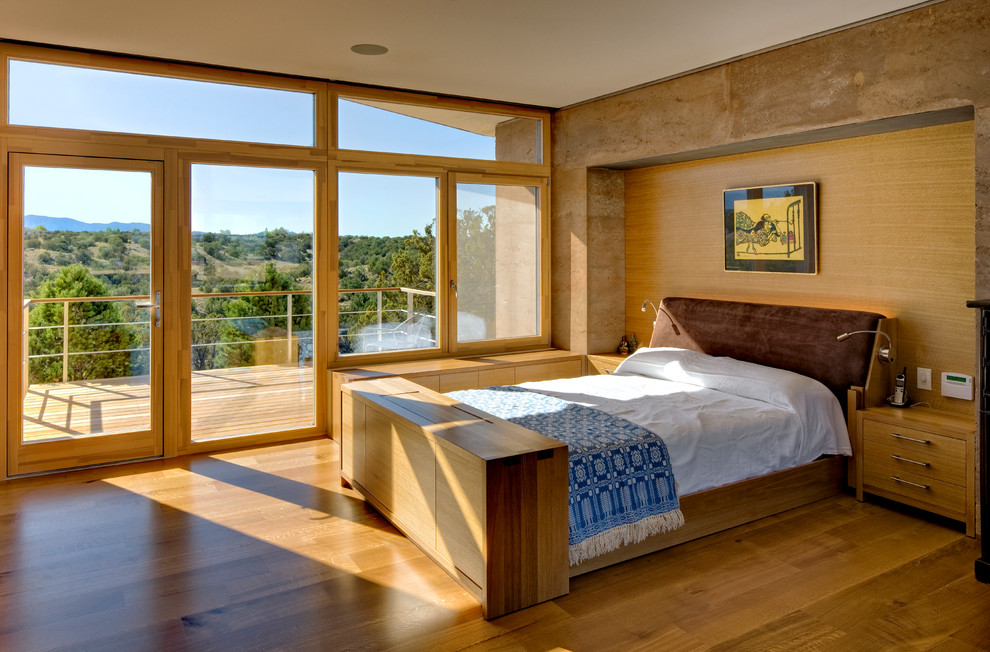 Mediterranes Hauptschlafzimmer mit grauer Wandfarbe, braunem Holzboden und braunem Boden in Denver