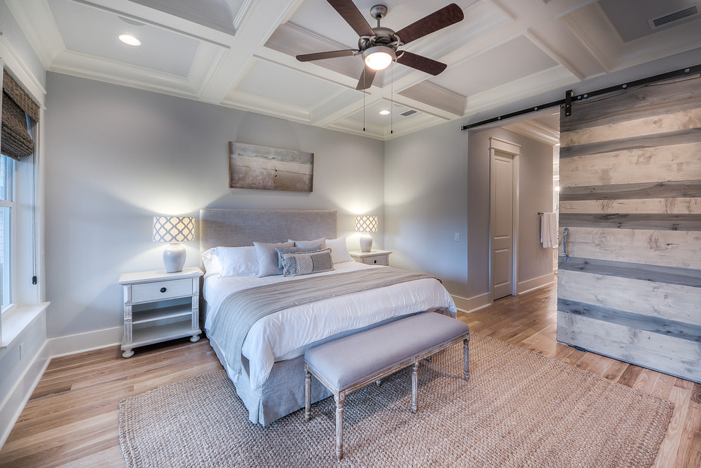 На фото: хозяйская спальня: освещение в морском стиле с серыми стенами и светлым паркетным полом с