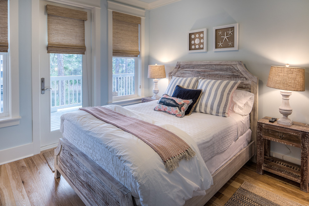 Ejemplo de habitación de invitados costera con suelo de madera clara y paredes azules