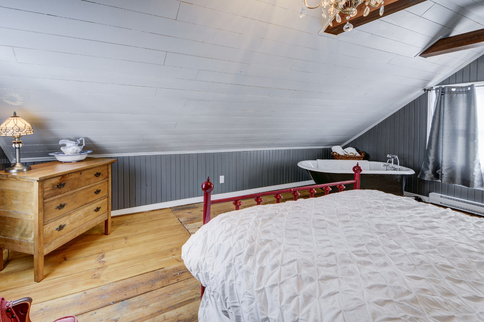 Großes Rustikales Hauptschlafzimmer mit grauer Wandfarbe und hellem Holzboden in Sonstige