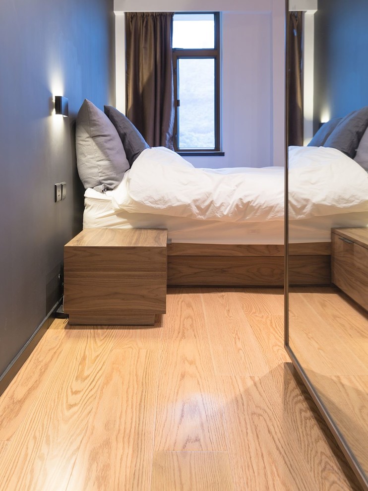 Kleines Industrial Hauptschlafzimmer ohne Kamin mit grauer Wandfarbe und Sperrholzboden in Hongkong