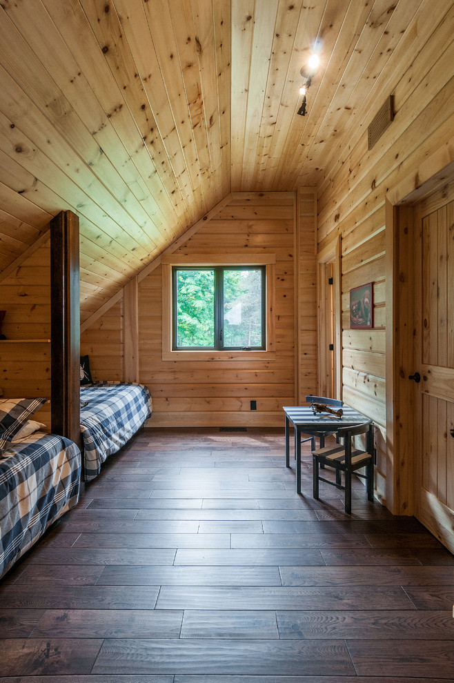 Ejemplo de dormitorio tipo loft rural de tamaño medio con paredes marrones y suelo de madera en tonos medios