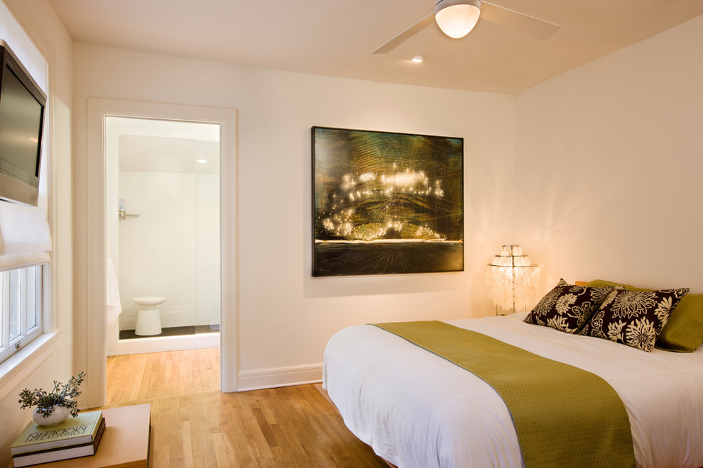 Réalisation d'une chambre tradition avec un mur beige et parquet clair.