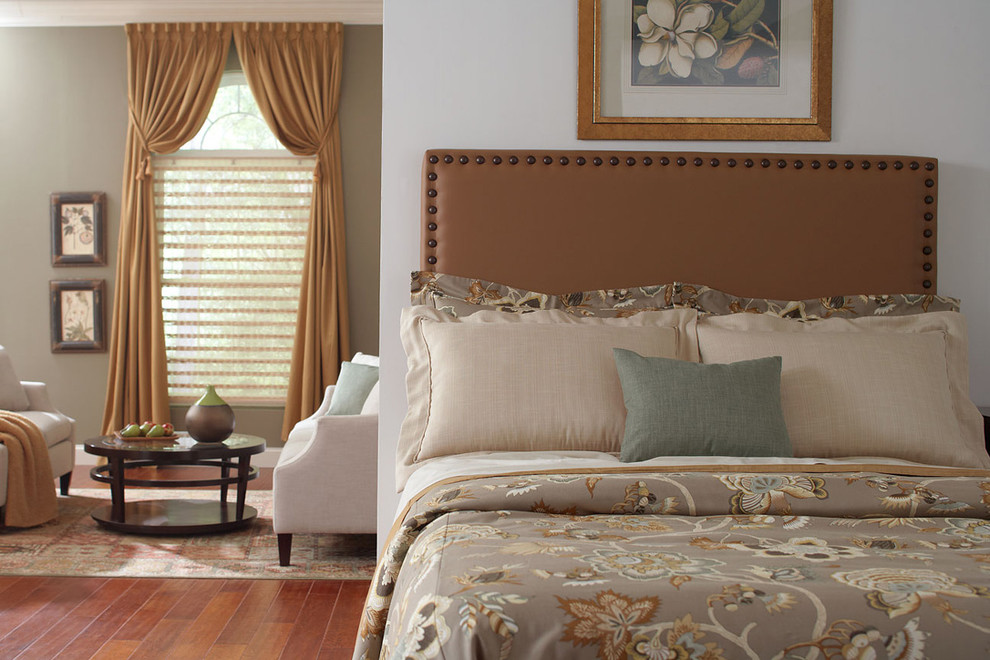 Modelo de dormitorio tipo loft clásico de tamaño medio sin chimenea con paredes azules y suelo de madera en tonos medios