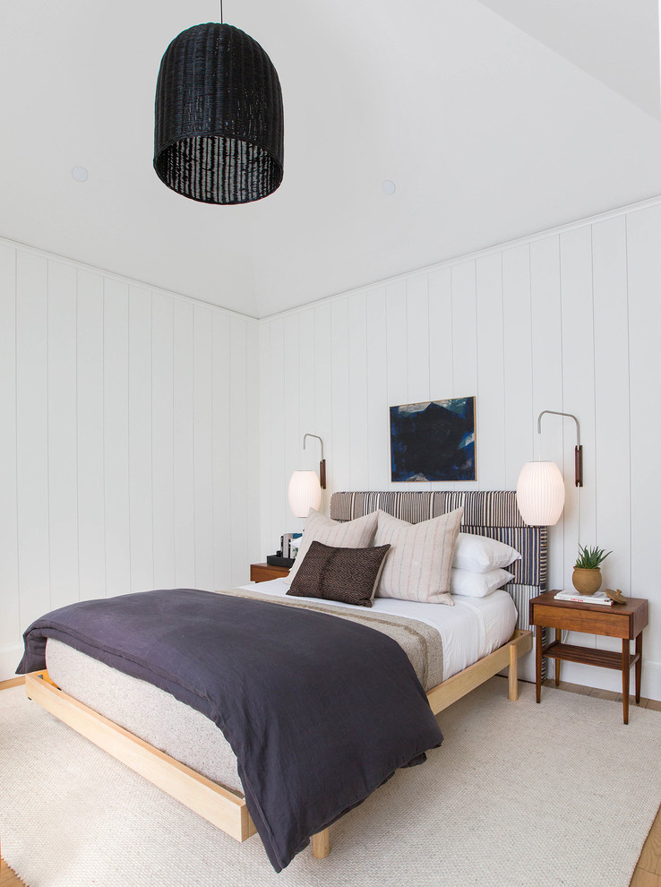 Idéer för lantliga sovrum, med vita väggar, mellanmörkt trägolv och brunt golv
