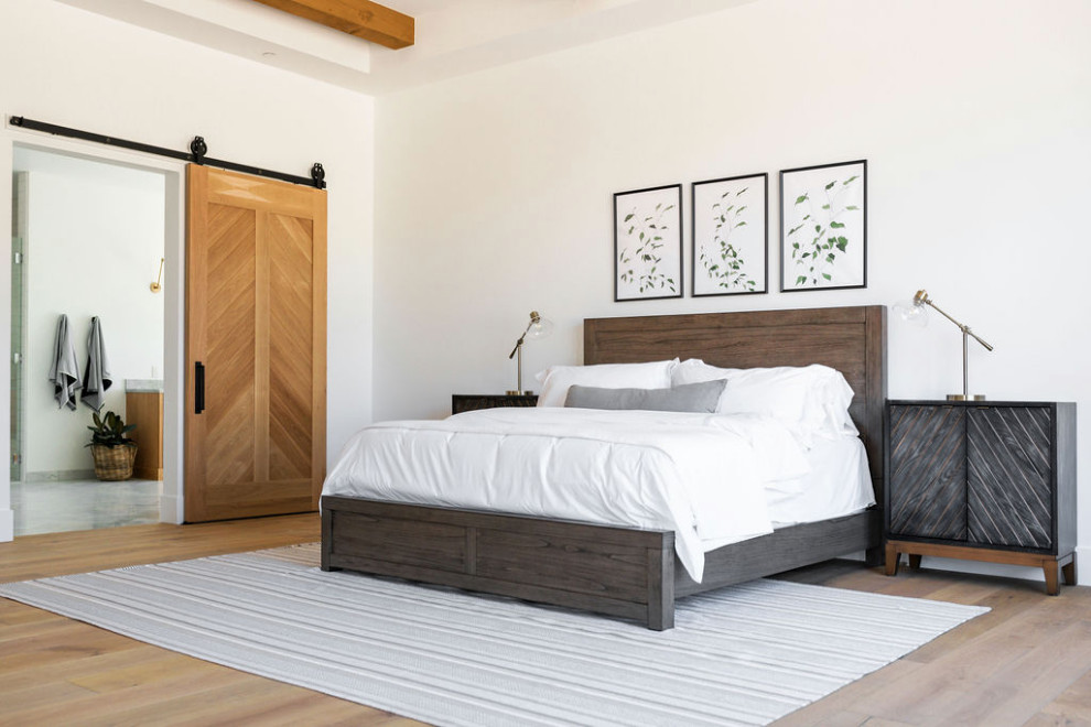Geräumiges Landhaus Hauptschlafzimmer mit weißer Wandfarbe, braunem Holzboden und braunem Boden in Phoenix
