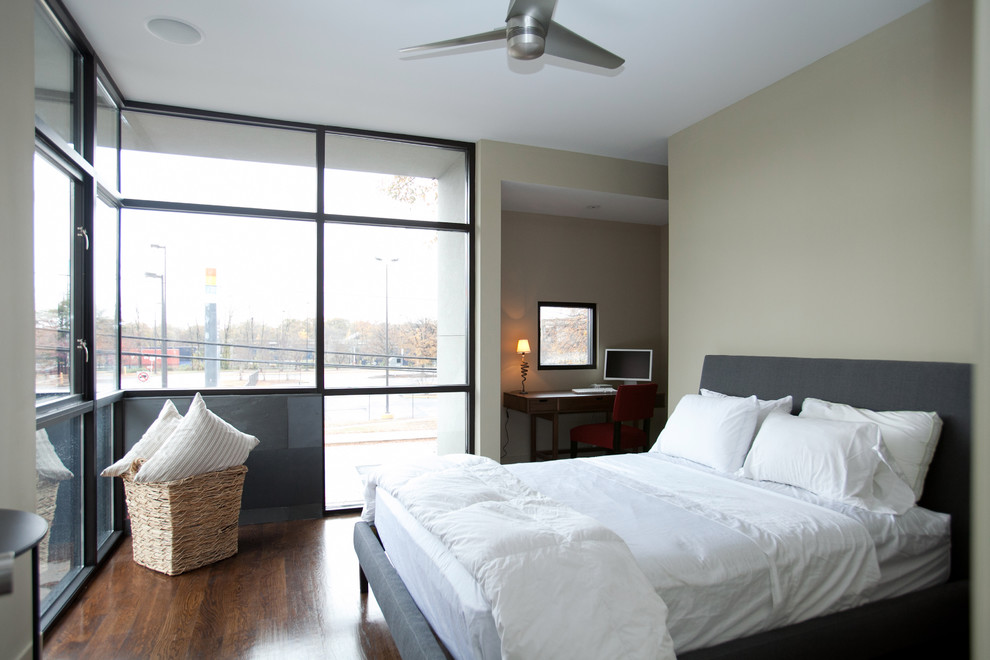Immagine di una camera da letto moderna con pareti beige e angolo studio