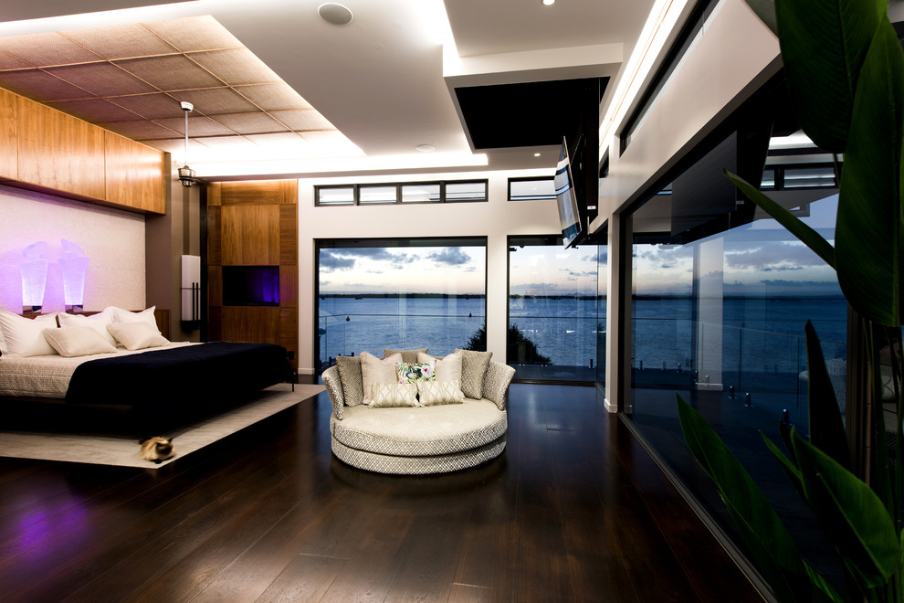 Geräumiges Hauptschlafzimmer mit weißer Wandfarbe und dunklem Holzboden in Gold Coast - Tweed