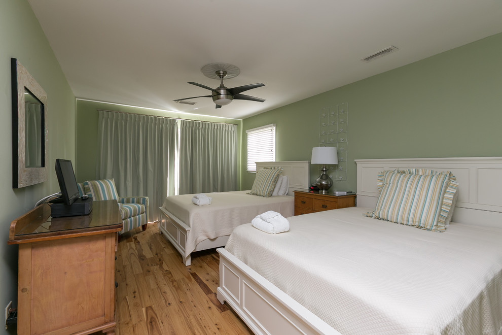 Esempio di una camera degli ospiti stile marino di medie dimensioni con pareti verdi e parquet chiaro