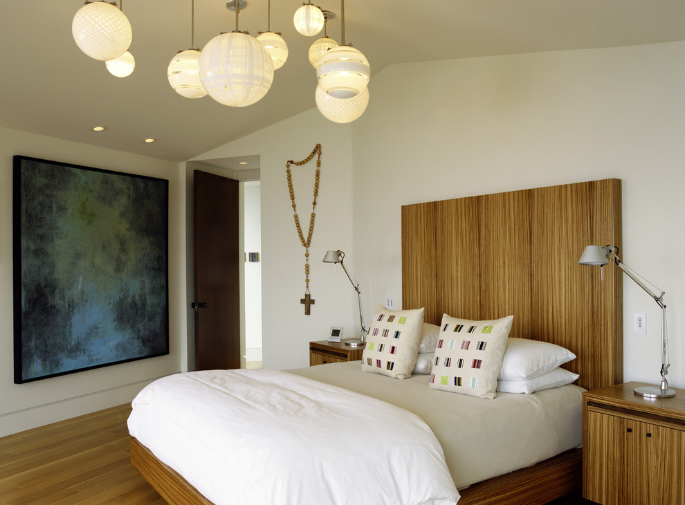 Пример оригинального дизайна: спальня в стиле модернизм с бежевыми стенами, паркетным полом среднего тона и тюлем