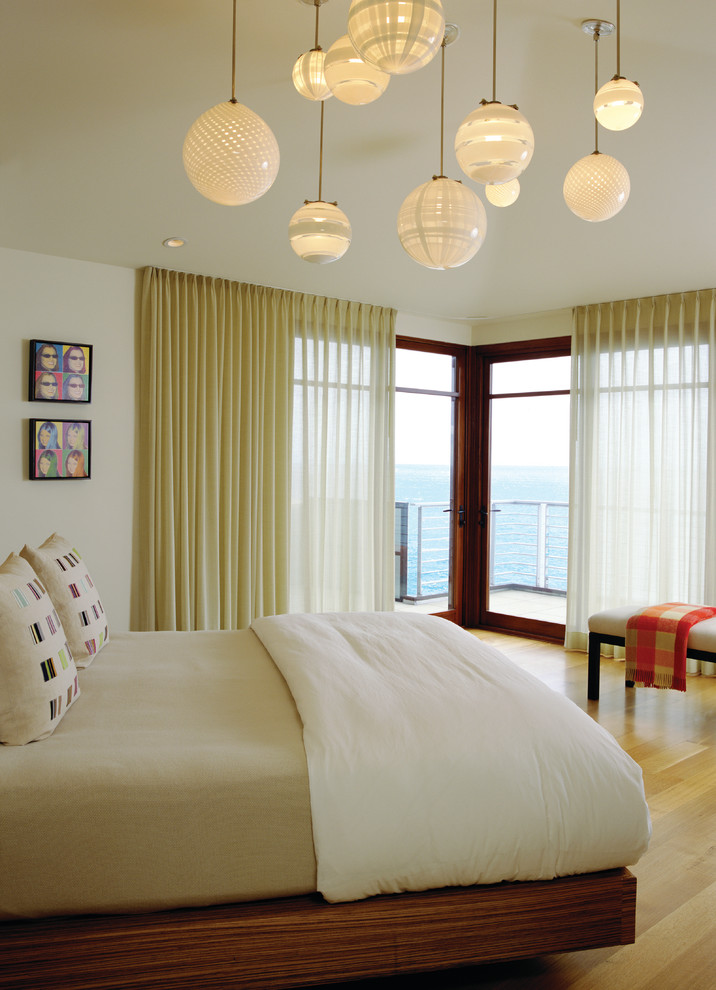 Modern bedroom in Orange County with beige walls and light hardwood flooring.