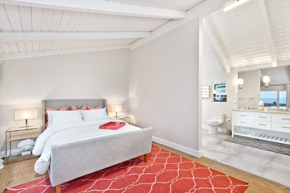Idée de décoration pour une chambre parentale design de taille moyenne avec un mur gris, parquet clair et un sol marron.