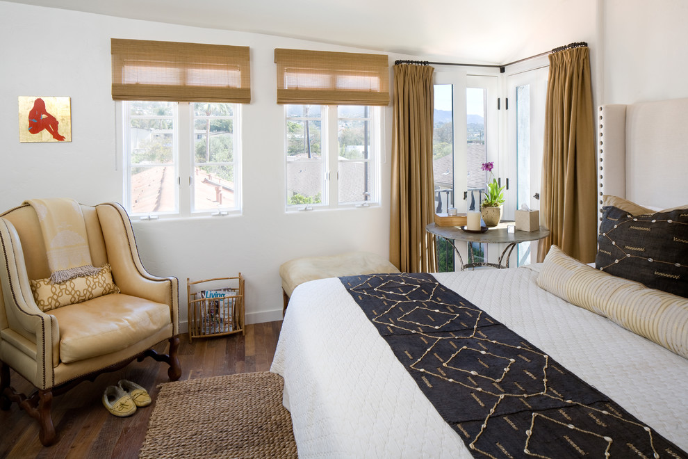 Modelo de dormitorio principal mediterráneo de tamaño medio con paredes blancas y suelo de madera en tonos medios