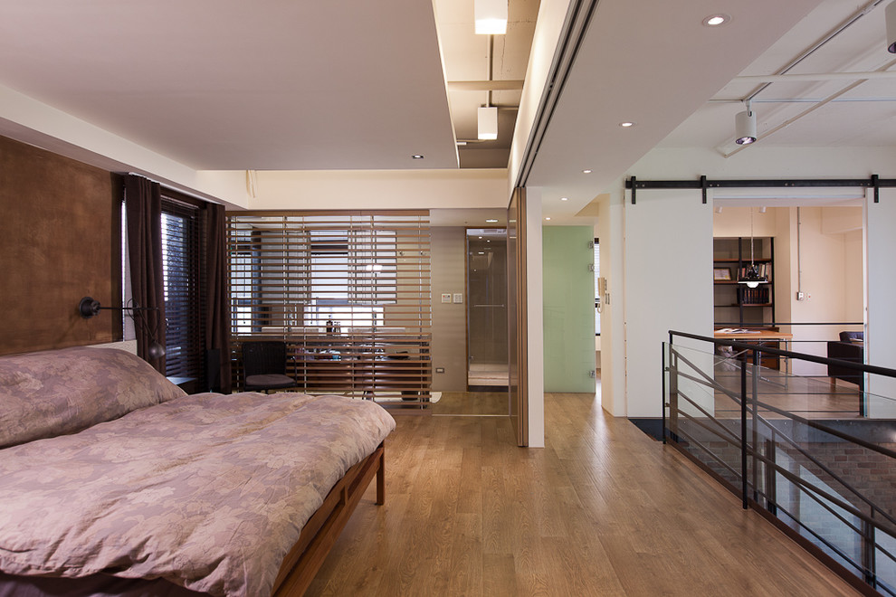 Modernes Schlafzimmer ohne Kamin, im Loft-Style mit weißer Wandfarbe und braunem Holzboden in Sonstige