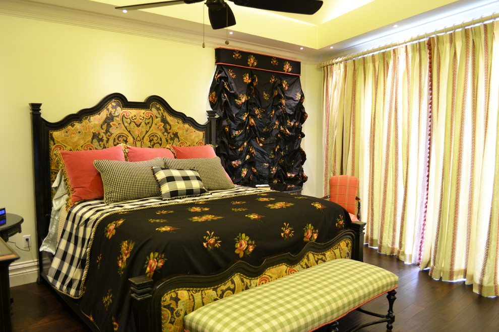 На фото: большая хозяйская спальня в стиле фьюжн с желтыми стенами и темным паркетным полом без камина с