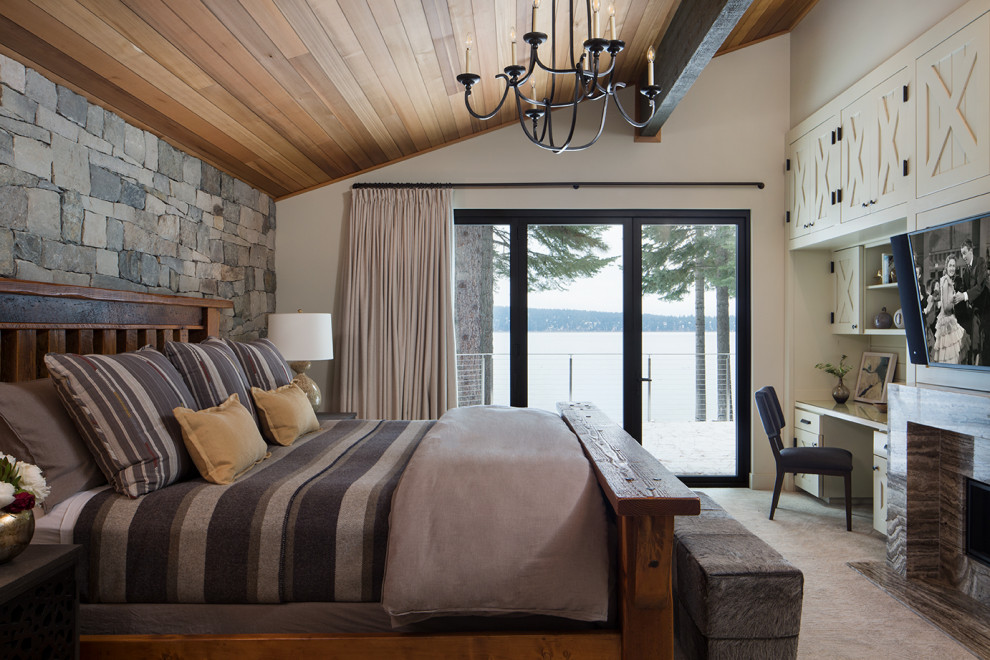 На фото: хозяйская спальня в морском стиле с белыми стенами, ковровым покрытием, горизонтальным камином, фасадом камина из камня, серым полом и деревянным потолком