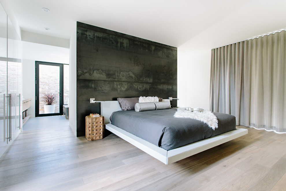 На фото: хозяйская спальня в стиле модернизм с черными стенами, светлым паркетным полом и бежевым полом с
