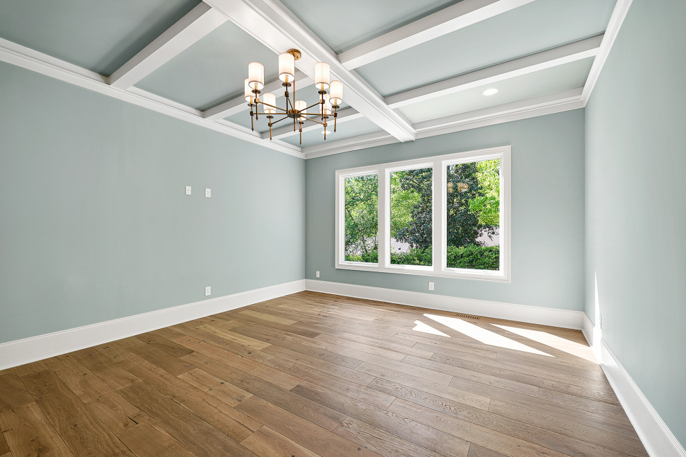 Photo of a large classic master bedroom in Raleigh with blue walls, medium hardwood flooring, brown floors and a coffered ceiling.