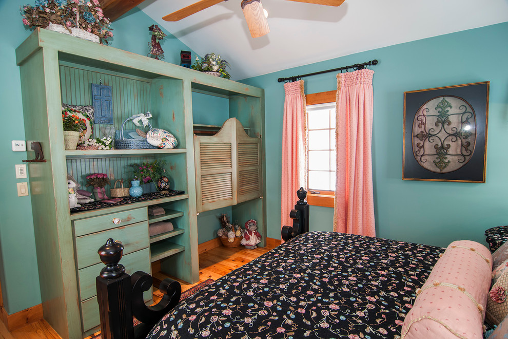 Ejemplo de habitación de invitados rural pequeña con suelo de madera en tonos medios y paredes azules