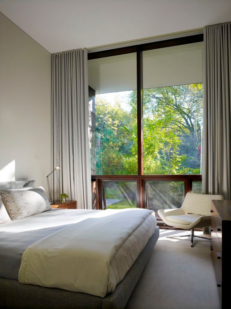 Diseño de dormitorio minimalista con paredes beige y moqueta