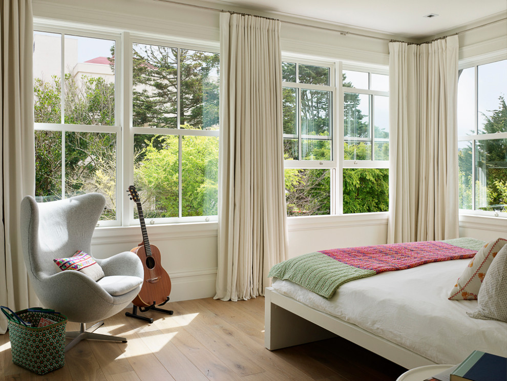 Imagen de dormitorio principal costero grande con suelo de madera clara