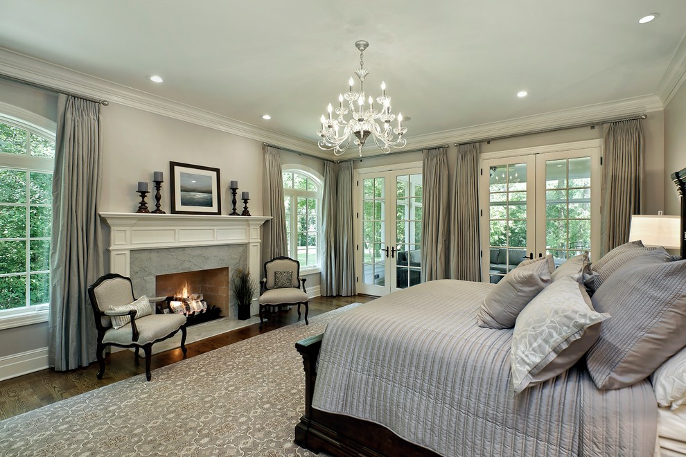 Inspiration for a classic master and grey and silver bedroom in Chicago with grey walls, dark hardwood flooring, a standard fireplace and a stone fireplace surround.
