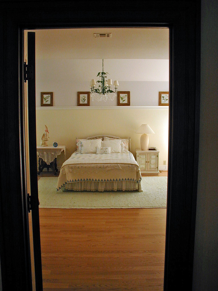 Foto de habitación de invitados tradicional grande con paredes amarillas y suelo de madera en tonos medios