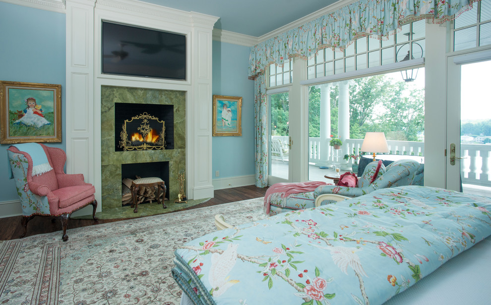 Ejemplo de dormitorio principal clásico con suelo de madera en tonos medios, todas las chimeneas y marco de chimenea de piedra
