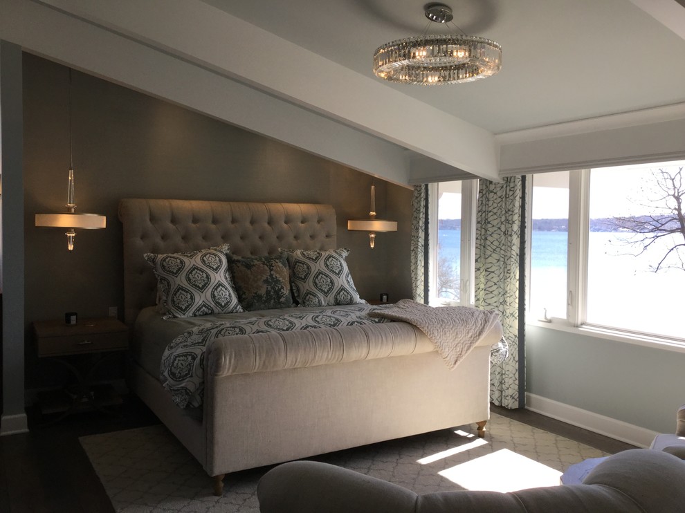 Design ideas for a medium sized beach style master bedroom in Milwaukee with blue walls, dark hardwood flooring, a ribbon fireplace, a stone fireplace surround and brown floors.
