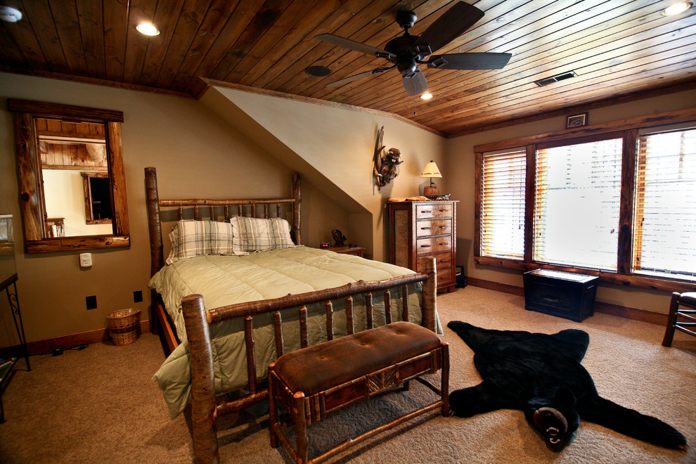 Large rustic master bedroom in Boston with beige walls, carpet and no fireplace.