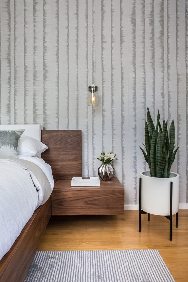 Modernes Hauptschlafzimmer mit grauer Wandfarbe, braunem Holzboden und orangem Boden in Los Angeles