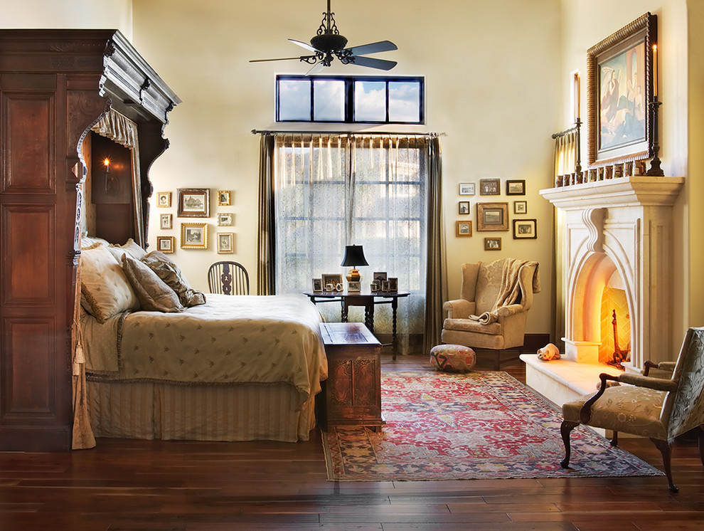 Mediterranes Hauptschlafzimmer mit beiger Wandfarbe, dunklem Holzboden und Kamin in Austin