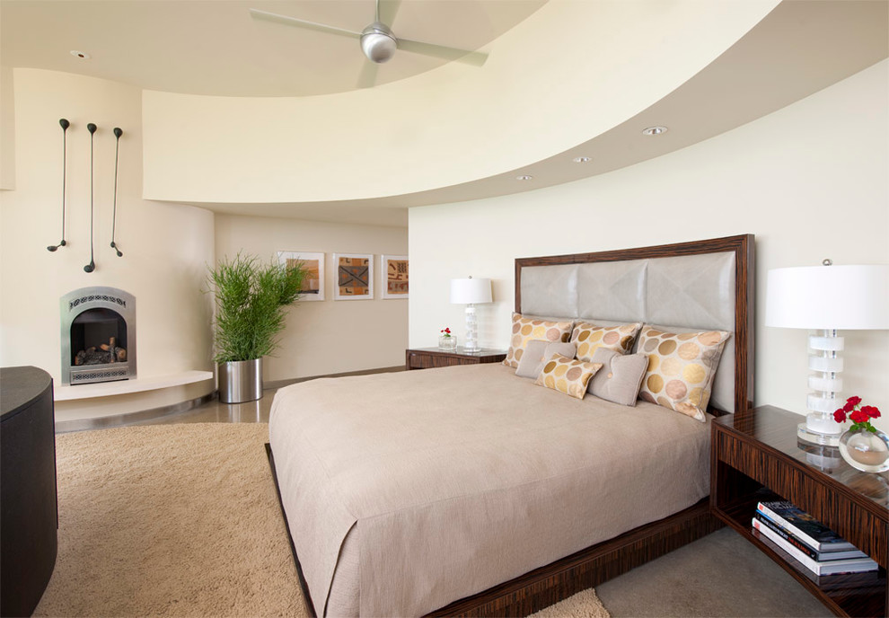 Imagen de dormitorio principal vintage grande con paredes beige, suelo de cemento, todas las chimeneas, marco de chimenea de yeso y suelo gris