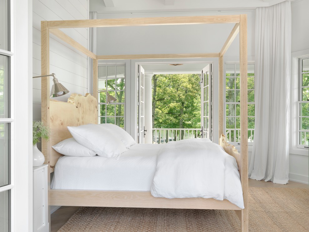 This is an example of a beach style bedroom in St Louis with white walls and light hardwood flooring.