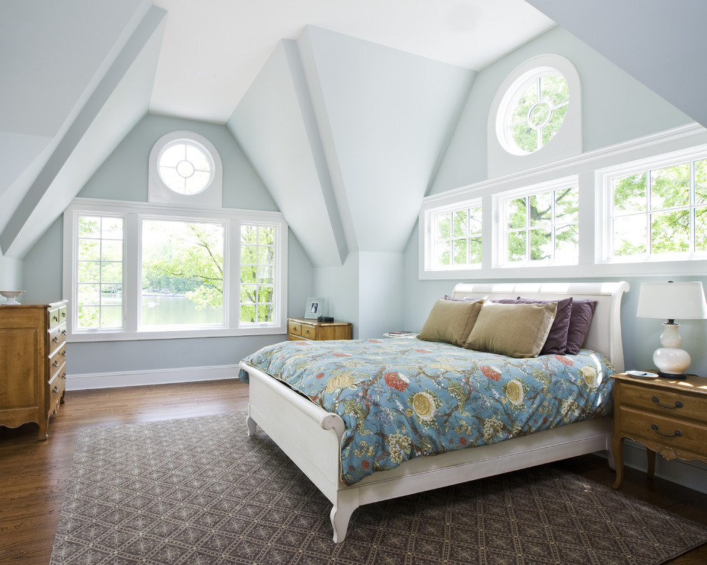 Elegant medium tone wood floor bedroom photo in New York with blue walls