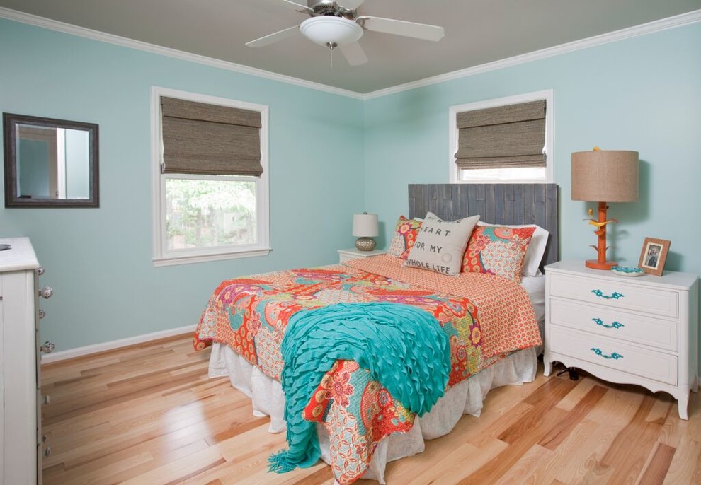 Cette photo montre une chambre parentale nature de taille moyenne avec un mur bleu et un sol en bois brun.