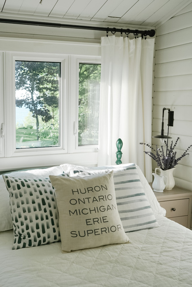 Kleines Maritimes Gästezimmer mit weißer Wandfarbe, braunem Holzboden, gewölbter Decke und Holzdielenwänden in Toronto