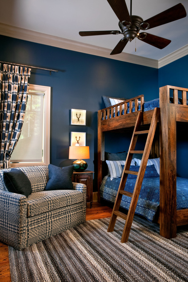 Immagine di una grande camera degli ospiti tradizionale con pareti blu e pavimento in legno massello medio