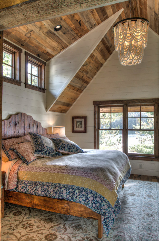 Imagen de dormitorio principal rural grande sin chimenea con paredes blancas, suelo de madera oscura y suelo marrón