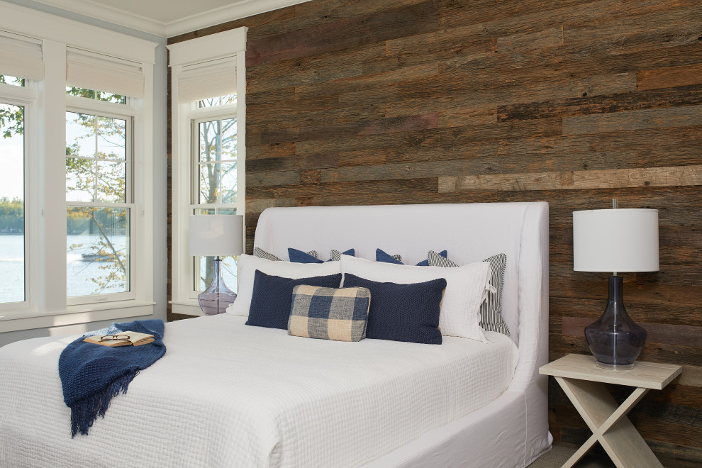 Maritimes Gästezimmer mit blauer Wandfarbe, Teppichboden, braunem Boden und Holzdielenwänden in Grand Rapids