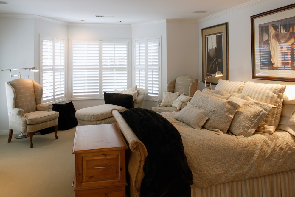 Ejemplo de dormitorio principal clásico de tamaño medio sin chimenea con paredes blancas y moqueta