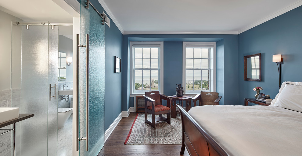 Idée de décoration pour une chambre parentale craftsman de taille moyenne avec un mur bleu, un sol en bois brun, aucune cheminée et un sol marron.