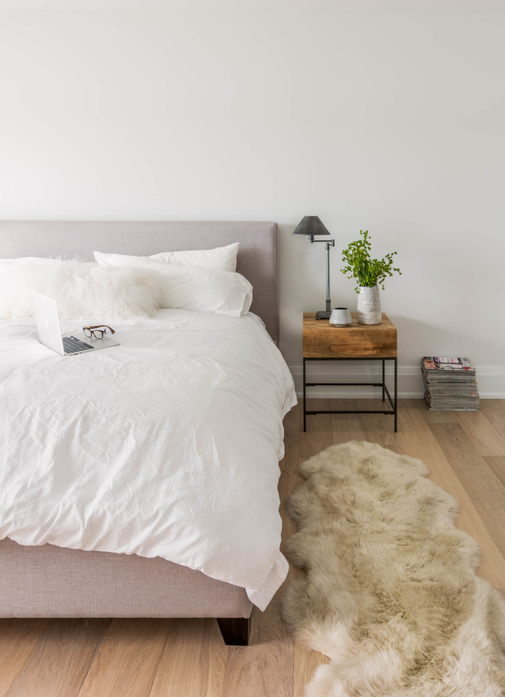 Nordisches Schlafzimmer mit weißer Wandfarbe und hellem Holzboden in Toronto