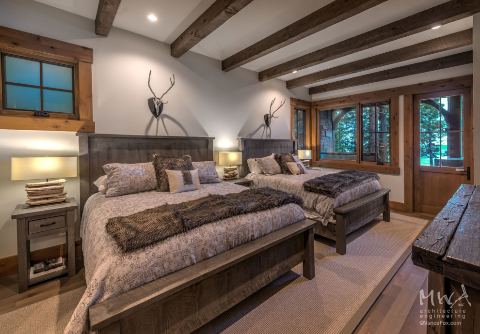 Immagine di una grande camera degli ospiti american style con pareti grigie, pavimento in legno massello medio e pavimento marrone