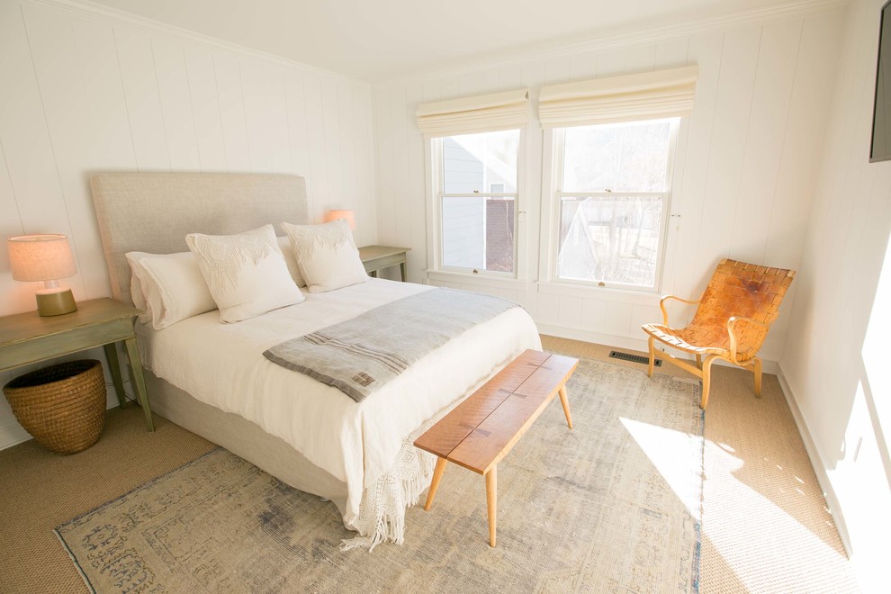 This is an example of a medium sized classic guest bedroom in Other with white walls and light hardwood flooring.
