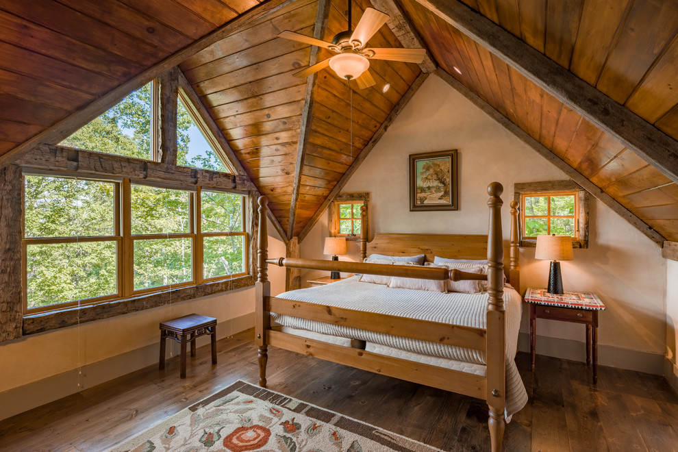 Example of a mid-sized mountain style medium tone wood floor bedroom design in Other with beige walls
